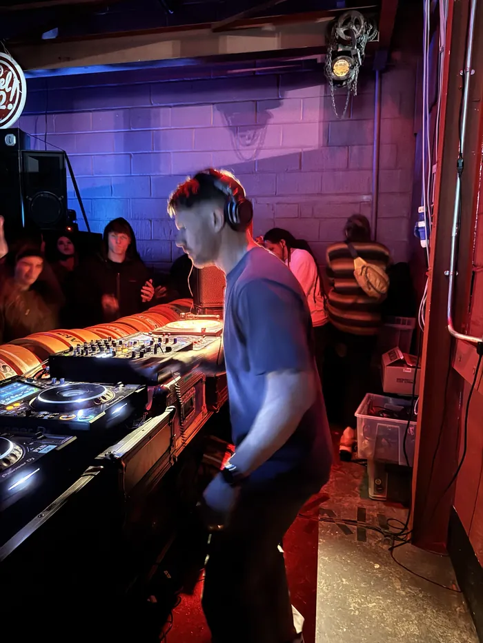Scruff Baggins DJing on Pioneer decks with the crowd right behind the booth
