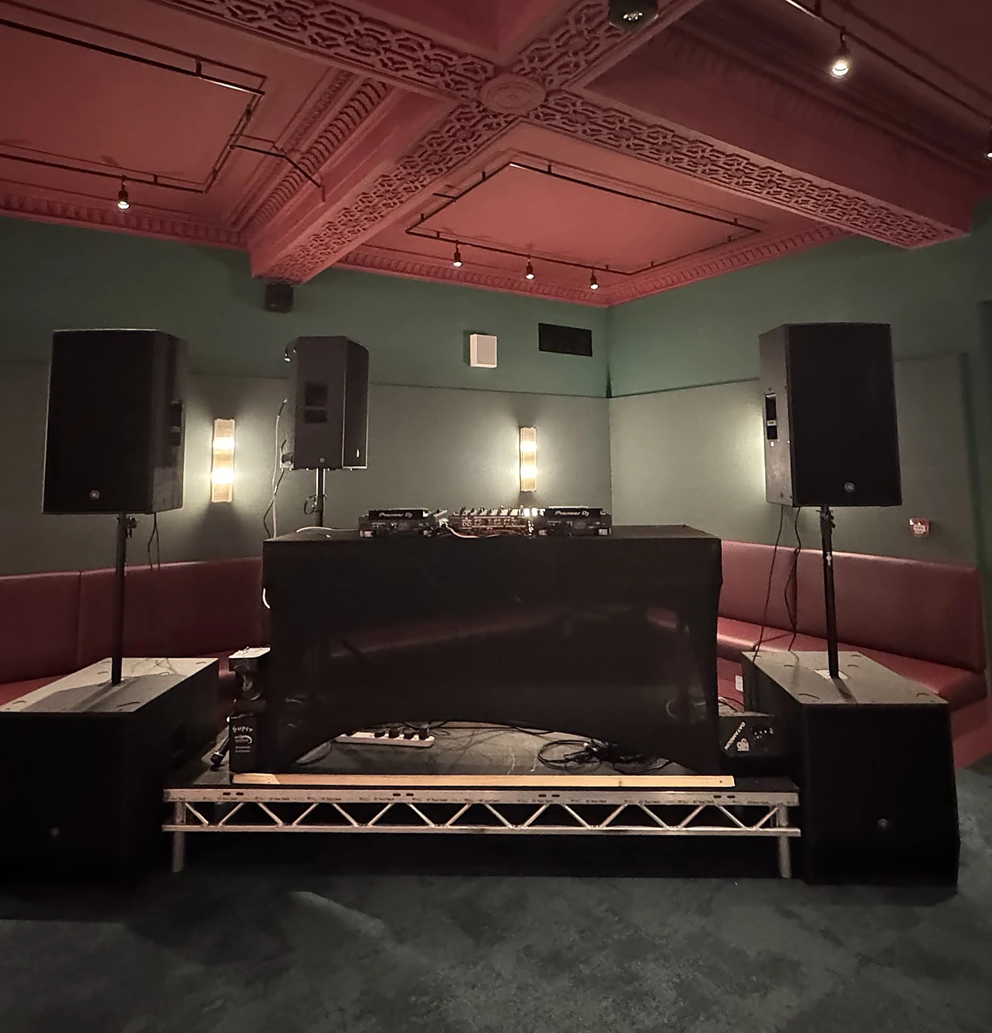 The Scruff Bag Sound System set up in a venue: Yamaha tops on stands over two subs, a booth monitor, and Pioneer decks on a DJ riser